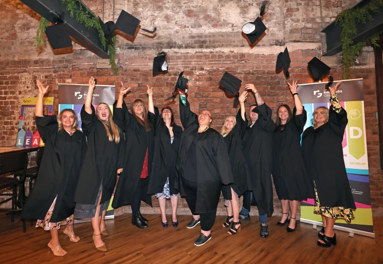 Group of graduates throwing their hats in the air