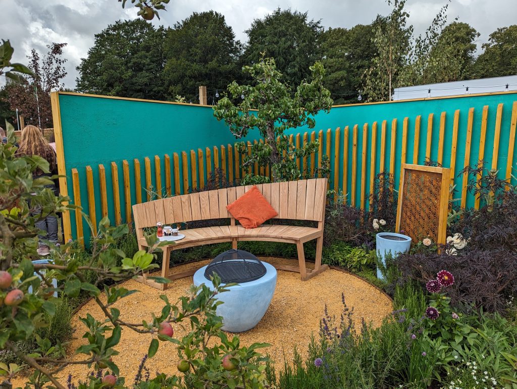Image of the Empowerment garden. Wooden bench and plants