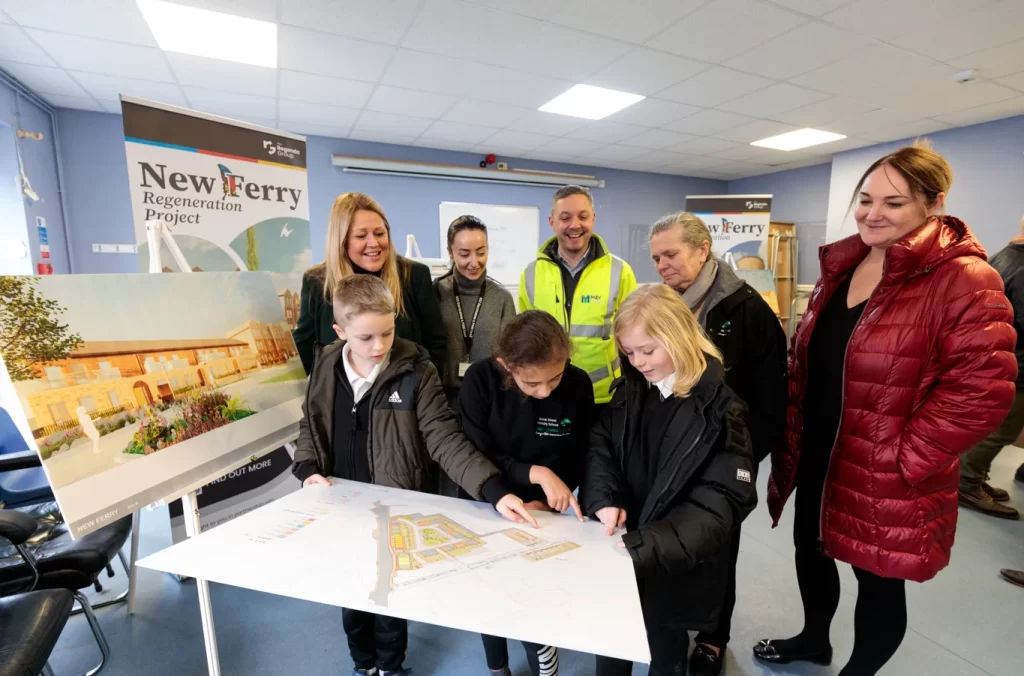 Children from local school looking at development plans, surrounded by representatives from Redwing, Regenda Homes, M&Y Maintenance and Construction,