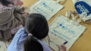 A girl decorates a Petrus canvas bag